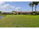 Beautifully landscaped backyard features a screened-in lanai and views of the tranquil lake and lush green lawn at 17923 Arbor Haven Dr, Tampa, FL 33647