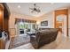 Comfortable living room featuring plush leather seating, a ceiling fan, and sliding glass doors to the outdoor space at 17923 Arbor Haven Dr, Tampa, FL 33647