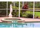 Poolside view of a luxurious jacuzzi surrounded by tropical plants and a picturesque landscape at 17923 Arbor Haven Dr, Tampa, FL 33647