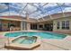 Inviting backyard pool area with a screened enclosure, swimming pool, spa, and outdoor seating area at 17923 Arbor Haven Dr, Tampa, FL 33647