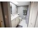 Bright bathroom with a skylight, decorative mirror, and ample cabinet space at 1846 Golfview Dr # 1846, Tarpon Springs, FL 34689