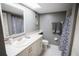 Bright bathroom featuring a skylight, decorative mirror, gray walls and neutral cabinets at 1846 Golfview Dr # 1846, Tarpon Springs, FL 34689