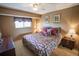 Cozy bedroom featuring a patterned bedspread, matching lamps, and a large window at 1846 Golfview Dr # 1846, Tarpon Springs, FL 34689