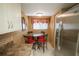 Cozy dining area adjacent to the kitchen featuring a glass table and stainless steel refrigerator at 1846 Golfview Dr # 1846, Tarpon Springs, FL 34689