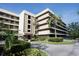 Modern condominium building featuring a well-maintained garden and mature palm trees at 1846 Golfview Dr # 1846, Tarpon Springs, FL 34689