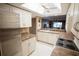 Well-lit kitchen featuring white cabinets, stainless steel refrigerator, and open layout to living area at 1846 Golfview Dr # 1846, Tarpon Springs, FL 34689