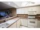 Bright kitchen features white cabinets, modern appliances, and a bar counter to dining area at 1846 Golfview Dr # 1846, Tarpon Springs, FL 34689