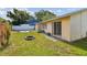 Well-maintained backyard featuring a fire pit, green grass, and a sliding glass door at 1944 Hastings Ln, Clearwater, FL 33763