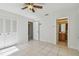 The bedroom leads to an attached bathroom featuring tiled floors and a ceiling fan at 1944 Hastings Ln, Clearwater, FL 33763