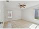 Neutral bedroom with tile floors featuring a ceiling fan and blinds for natural light at 1944 Hastings Ln, Clearwater, FL 33763