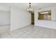 Open dining space with white tile, a decorative chandelier, and kitchen view at 1944 Hastings Ln, Clearwater, FL 33763