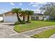 Charming single-story home with palm trees, lush lawn, and a two-car garage at 1944 Hastings Ln, Clearwater, FL 33763