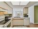 Kitchen with stainless steel microwave, white counters, and view into the dining area and backyard at 1944 Hastings Ln, Clearwater, FL 33763