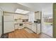 Bright kitchen with white appliances, cabinetry, skylight, and an adjacent dining area offering a view to the backyard at 1944 Hastings Ln, Clearwater, FL 33763