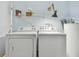 Functional laundry room with washer, dryer, and overhead storage space at 1944 Hastings Ln, Clearwater, FL 33763