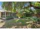 Expansive backyard with a screened porch, lush lawn, and mature landscaping, great for relaxation and outdoor activities at 2136 Cunningham Dr, Clearwater, FL 33763