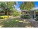 Spacious backyard with lush greenery, a screened porch, and mature trees, perfect for enjoying the outdoors at 2136 Cunningham Dr, Clearwater, FL 33763