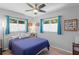 Cozy bedroom features hardwood floors, natural lighting, a ceiling fan, and soothing blue curtains at 2136 Cunningham Dr, Clearwater, FL 33763