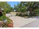 Charming single-story home featuring a paved driveway, lush landscaping, and a white picket fence for added privacy at 2136 Cunningham Dr, Clearwater, FL 33763