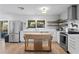 Modern kitchen with white cabinets, stainless steel appliances, a kitchen island, and hardwood floors at 2136 Cunningham Dr, Clearwater, FL 33763