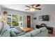 Comfortable living room with a cozy blue sectional couch, TV, hardwood floors, and a bright window at 2136 Cunningham Dr, Clearwater, FL 33763