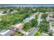 An aerial view of a property showcasing a backyard pool, solar panels, and lush landscaping in a desirable neighborhood at 313 Oak Crest Dr, Safety Harbor, FL 34695