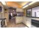 Kitchen with tile floor, white cabinets, black appliances, and window overlooking the patio and back yard at 313 Oak Crest Dr, Safety Harbor, FL 34695