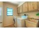 Functional laundry room with overhead cabinets, washer, dryer, and utility sink perfect for household chores at 313 Oak Crest Dr, Safety Harbor, FL 34695