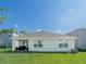 Well-maintained backyard featuring a covered patio and lush green lawn, ideal for outdoor activities at 33488 Elm Hill Br, Wesley Chapel, FL 33545