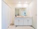 Bright bathroom features dual sinks, white cabinets, and a shower with a white curtain at 33488 Elm Hill Br, Wesley Chapel, FL 33545