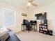 Bright bedroom featuring carpeted floors, a modern ceiling fan, and an entertainment center with a large screen TV at 33488 Elm Hill Br, Wesley Chapel, FL 33545