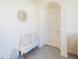 Inviting entryway with a decorative round mirror and bench with throw pillows and a blanket at 33488 Elm Hill Br, Wesley Chapel, FL 33545