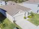 Aerial view of home exterior with well-manicured lawn, garden, and a two-car garage at 33488 Elm Hill Br, Wesley Chapel, FL 33545