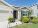 Inviting front entrance with landscaping, security system sign and dark-stained front door at 33488 Elm Hill Br, Wesley Chapel, FL 33545