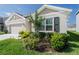 Charming front yard with lush landscaping, shrubbery, and a shade tree at 33488 Elm Hill Br, Wesley Chapel, FL 33545
