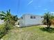 Exterior view of the home showing a green lawn and tropical landscaping elements at 34041 Azalea N Dr, Pinellas Park, FL 33781