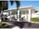 Charming clubhouse exterior featuring a covered entrance, well-maintained landscaping, and ample parking at 34041 Azalea N Dr, Pinellas Park, FL 33781
