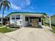 Mobile home with a covered carport showcasing the front facade and landscaping at 34041 Azalea N Dr, Pinellas Park, FL 33781