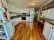 Bright kitchen with white cabinets, stainless steel appliances, and a functional layout with wood-look vinyl flooring at 34041 Azalea N Dr, Pinellas Park, FL 33781