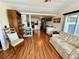 Open-concept living room showcasing wood flooring, a comfortable sofa, a bar area, and a view into the kitchen at 34041 Azalea N Dr, Pinellas Park, FL 33781