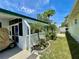 Landscaped side yard featuring tropical plants and a covered carport area at 34041 Azalea N Dr, Pinellas Park, FL 33781