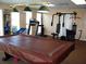 Well-equipped exercise room with treadmill, weight machines, and a pool table for active recreation at 34041 Azalea N Dr, Pinellas Park, FL 33781