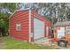 Exterior view of a red steel garage featuring a roll-up door and side entrance at 3424 16Th E St, Bradenton, FL 34208
