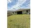 Backyard view reveals a covered patio and a lush, grassy lawn in a residential neighborhood at 3504 Crooked River Dr, Plant City, FL 33565