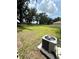Fenced backyard shows grassy lawn and mature trees with an outdoor AC unit at 3504 Crooked River Dr, Plant City, FL 33565