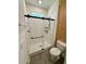 Bathroom featuring tiled walk in shower with a glass slider door, toilet and wood paneling at 3504 Crooked River Dr, Plant City, FL 33565