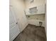 Functional laundry room with tile floors, overhead cabinets, and utility connections at 3504 Crooked River Dr, Plant City, FL 33565