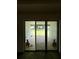 Covered patio with sliding glass doors leading to a fenced backyard with green grass at 3504 Crooked River Dr, Plant City, FL 33565