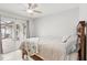 This comfortable bedroom features a ceiling fan, a large sliding door, and decorative bedding at 3966 High Bluff Dr, Largo, FL 33770