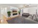 Comfortable living room features an electric fireplace, a ceiling fan, large windows, and hardwood flooring at 3966 High Bluff Dr, Largo, FL 33770
